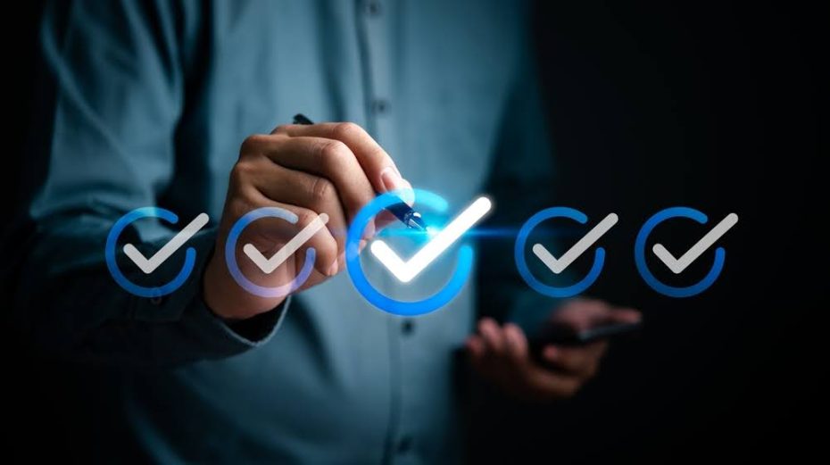 A hand holding a pen behind checkmarks in the foreground